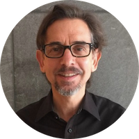 headshot of man with short hair and gray beard wearing square black glasses